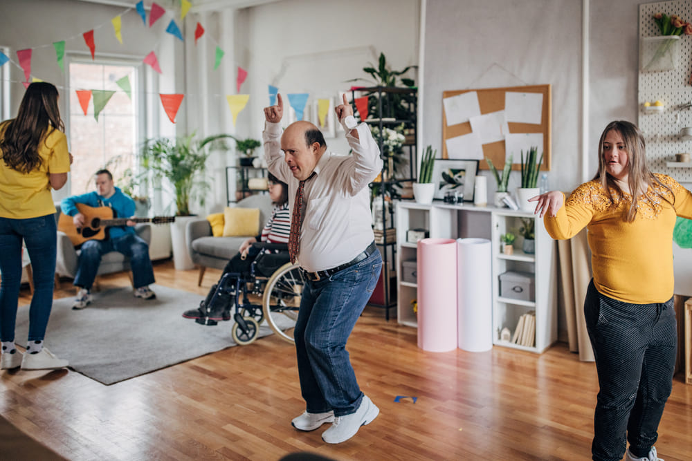 A group of people are enjoying a cracking party indoors, indicated by the bunting strung up across the room.