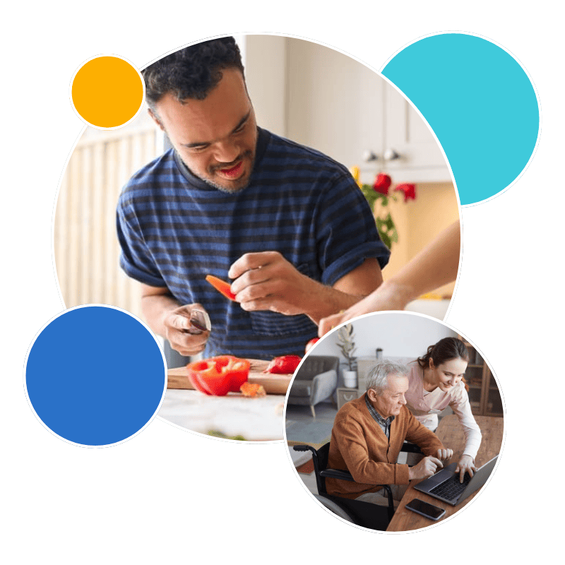 A man with Down syndrome focused on cutting a red bell pepper in a bright kitchen and a senior man who is seated in a wheelchair focused on a laptop screen.