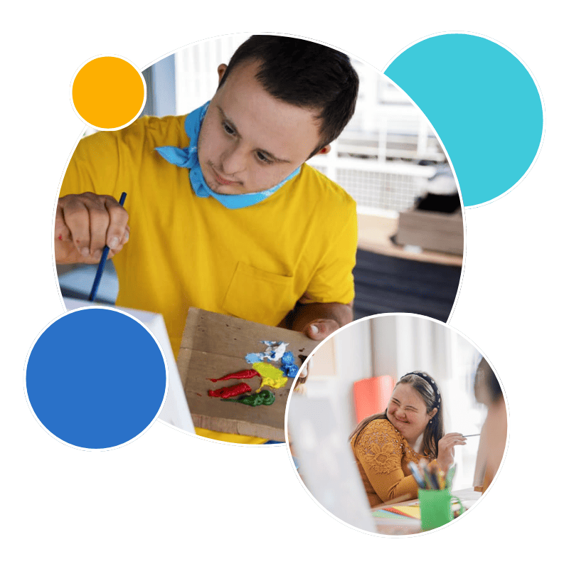 A young man with Down syndrome is actively engaged in painting and a young woman smiling while holding a paintbrush.
