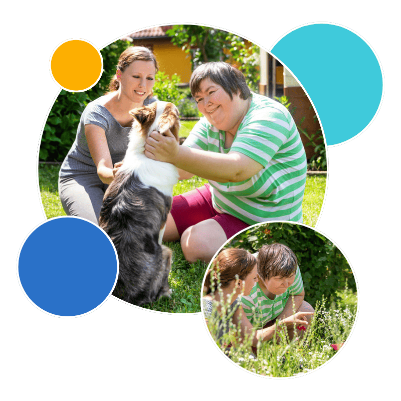 A woman with Down syndrome kneeling on the grass and affectionately petting a border collie and woman kneeling in a garden area looking closely at a flower with red blossoms.